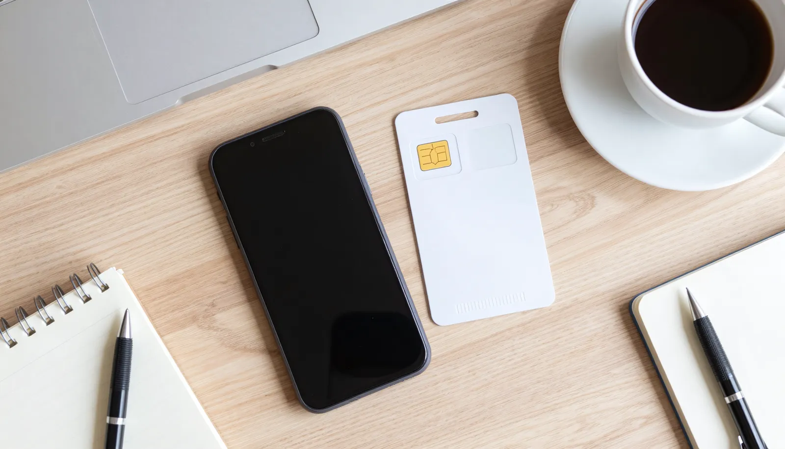 Kontantkort mobil med SIM-kort og telefon på skrivebord