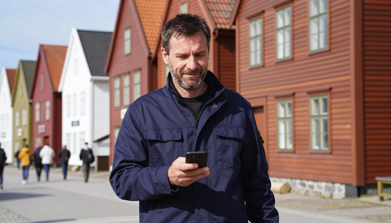 Konto w norweskim banku – mężczyzna na nabrzeżu Bryggen w Bergen załatwia sprawy w telefonie
